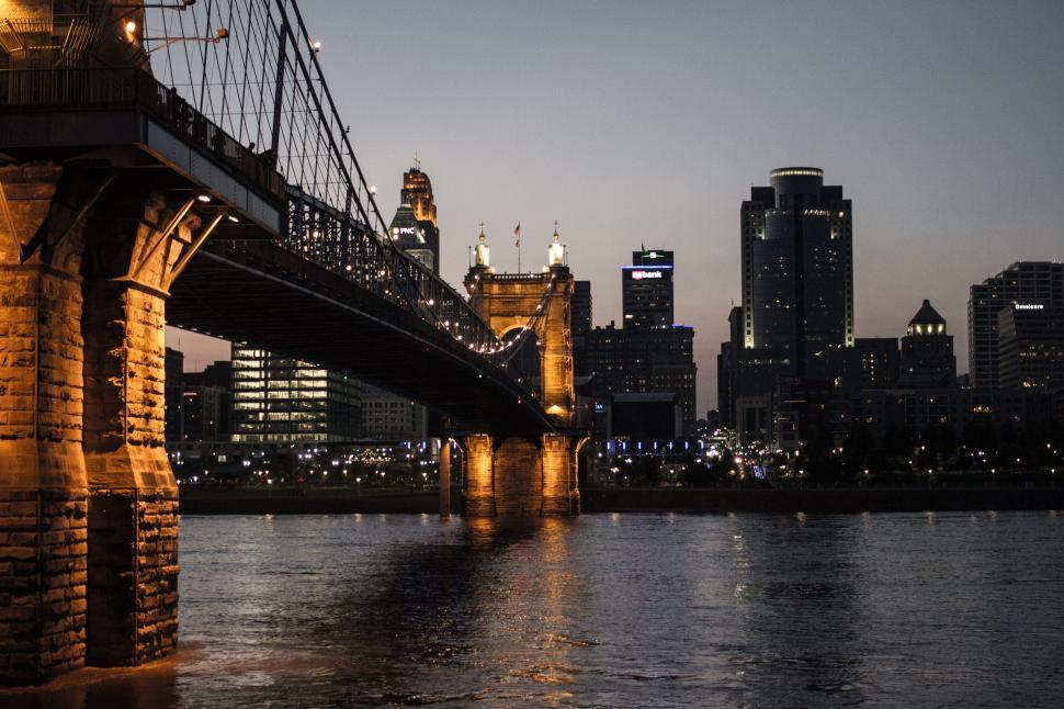 Free Image of Bridge over tranquil river with city skyline night view 