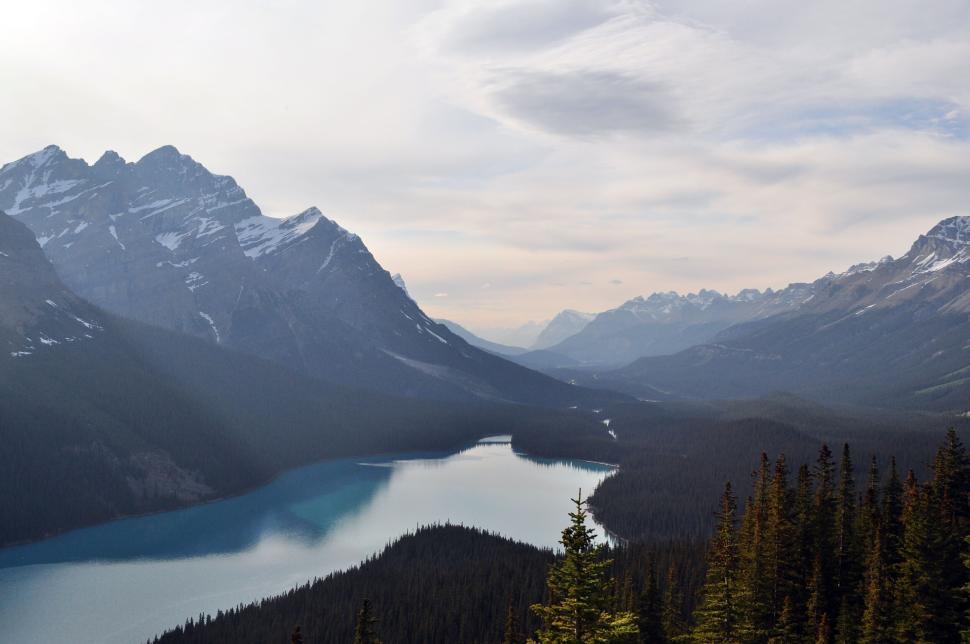 Free Image of Serene lake with mountain range and forest foreground 