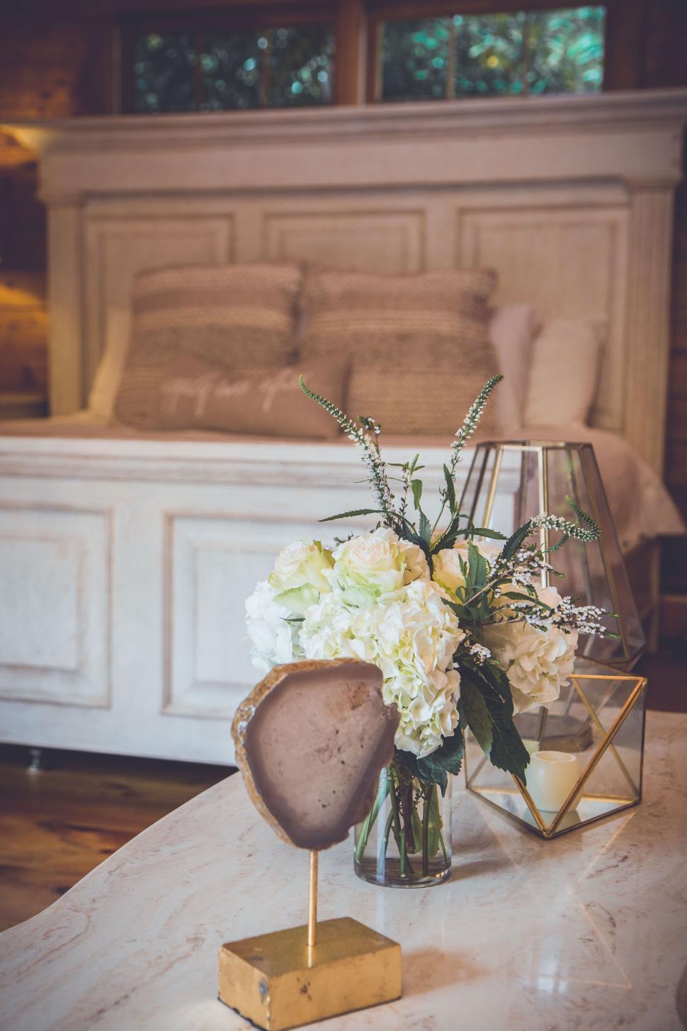 Free Image of Elegant bedroom decor with floral arrangement and stone 