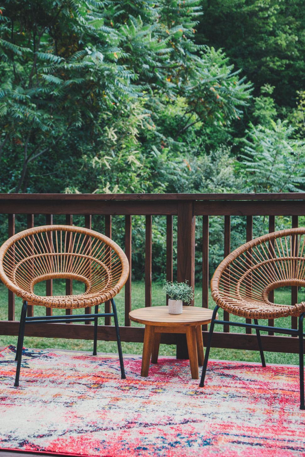Free Image of Outdoor wicker chairs and table on a colorful rug. 