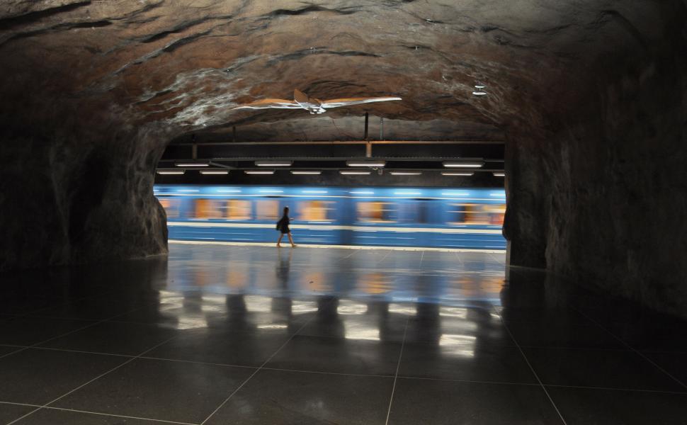 Free Image of Silhouette of person with fast moving train in tunnel 
