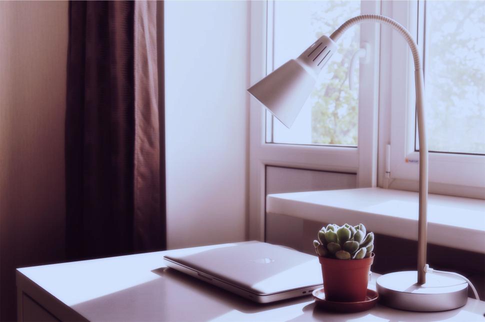 Free Image of Modern desk with laptop, lamp, and potted plant. 