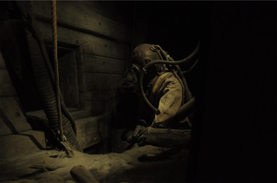 Free Image of Diver in an eerie, dark, abandoned underwater setting. 