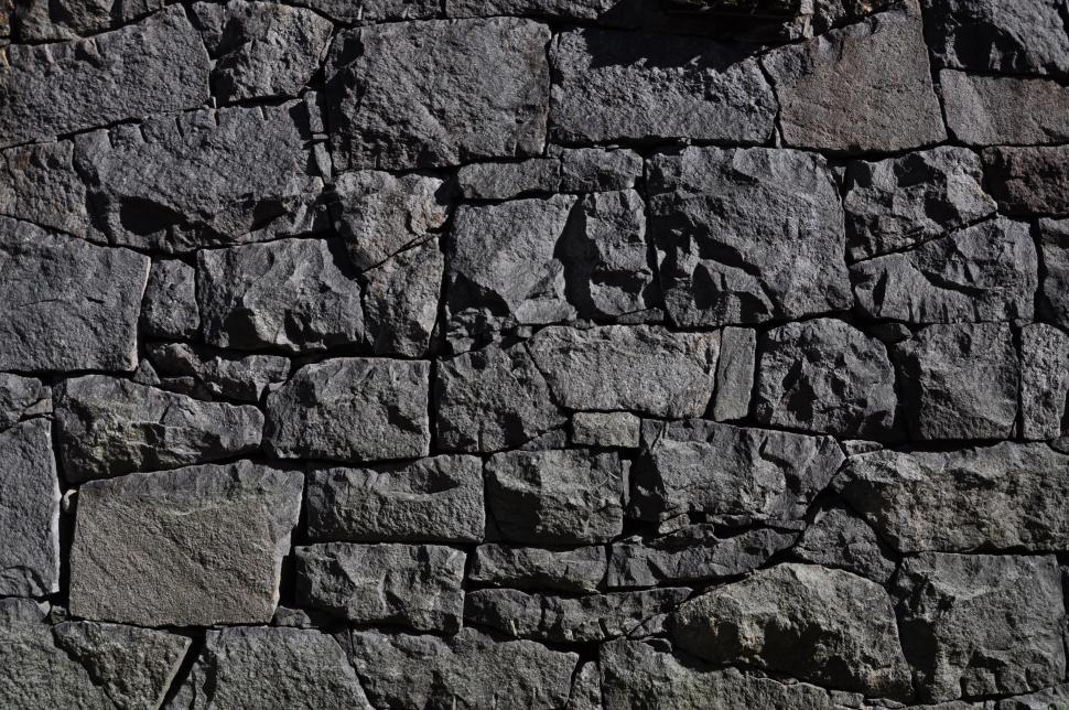 Free Image of Close-up of rough, textured stone wall in daylight. 