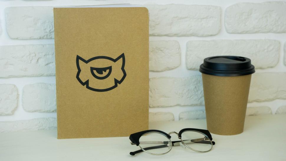 Free Image of Notebook, glasses, and coffee cup on a white desk. 