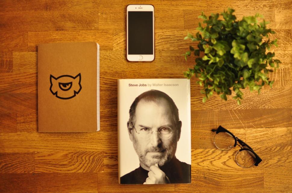Free Image of Items on wooden table including book, phone, notebook. 