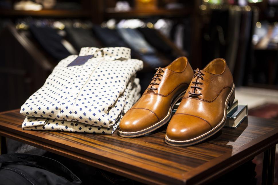 Free Image of Polished leather shoes and a folded shirt on display. 