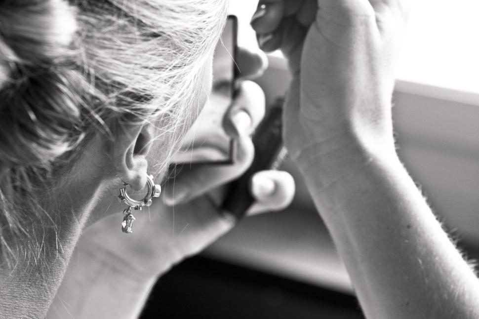 Free Image of Person looking in a mirror adjusting their appearance. 
