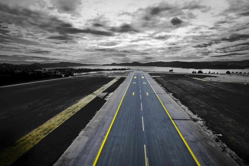 Free Image of Runway stretching into the distance under cloudy skies. 