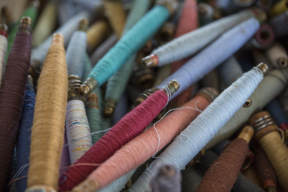 Free Image of Colorful spools of thread in various shades and textures 
