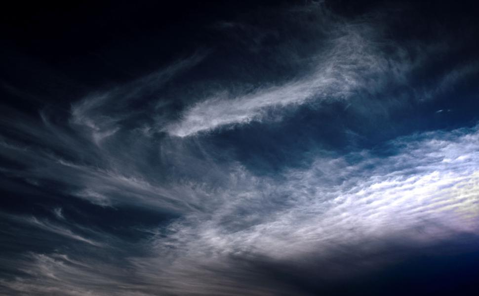 Free Image of Dynamic sky with swirling clouds reflecting light artfully 