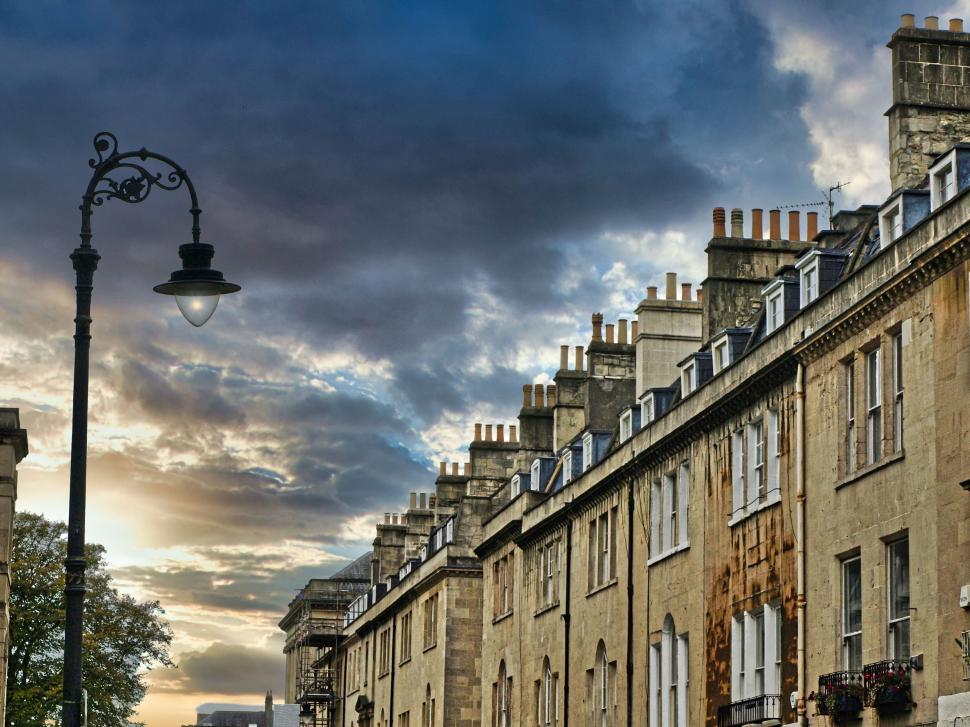 Free Image of Row of traditional stone houses under dramatic cloudy sky 