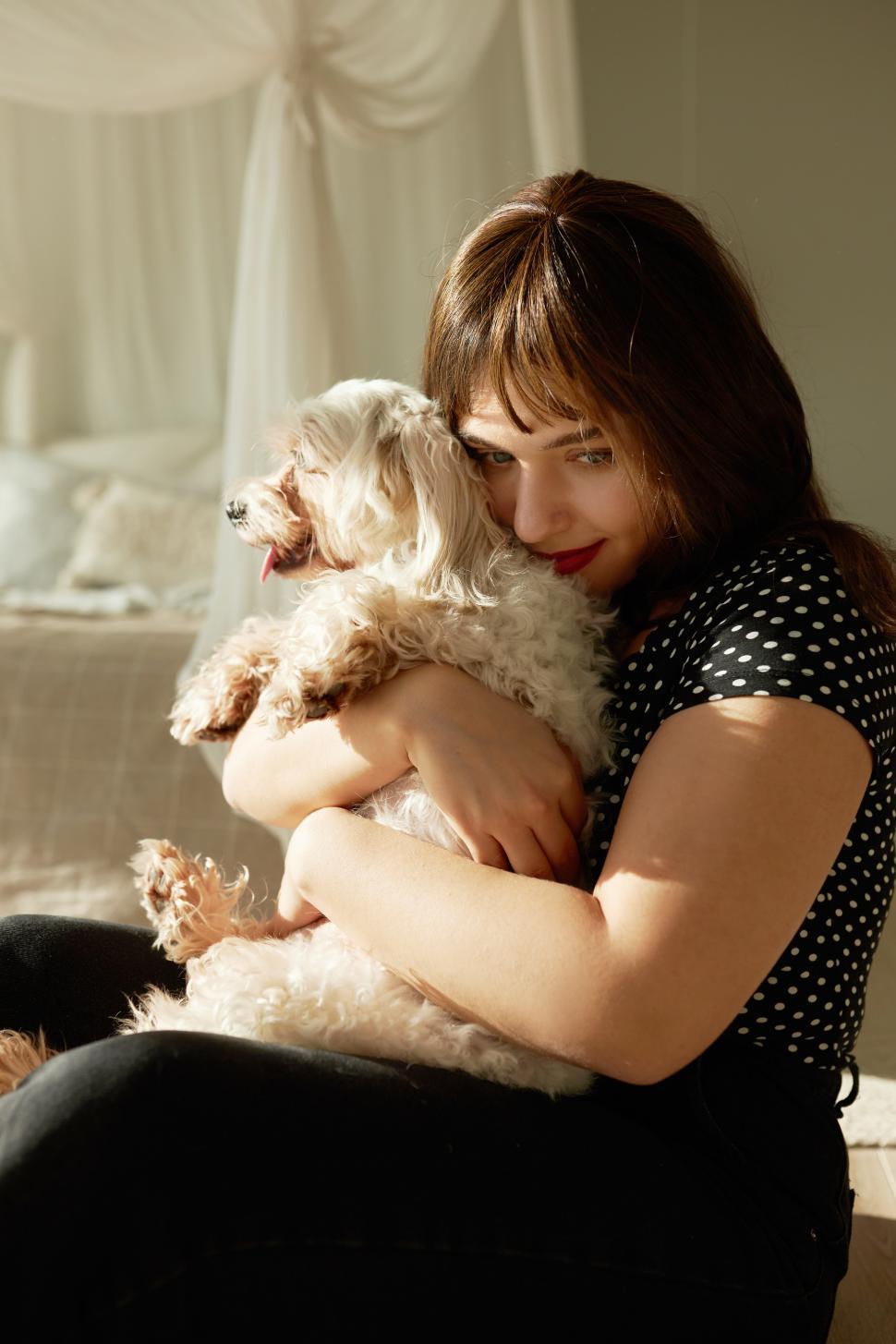Free Image of Sad girl of 20s hugging her pet tightly after coming home from bad date or splitting up with her boyfriend, feeling lonely, showing her love and affection to dog, feeling lonely and abandoned 