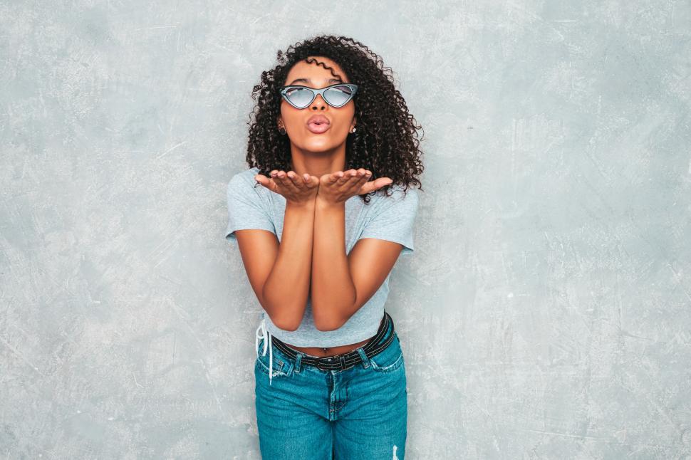 Free Image of Woman blowing a kiss, wears sunglasses, casual style 