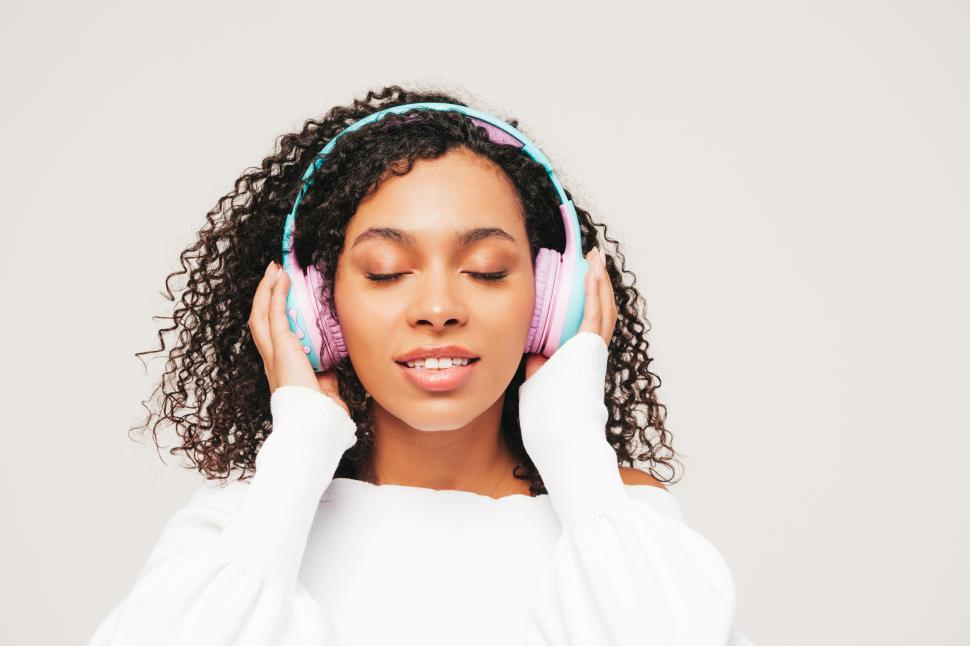 Free Image of Woman enjoying music with closed eyes wearing headphones. 