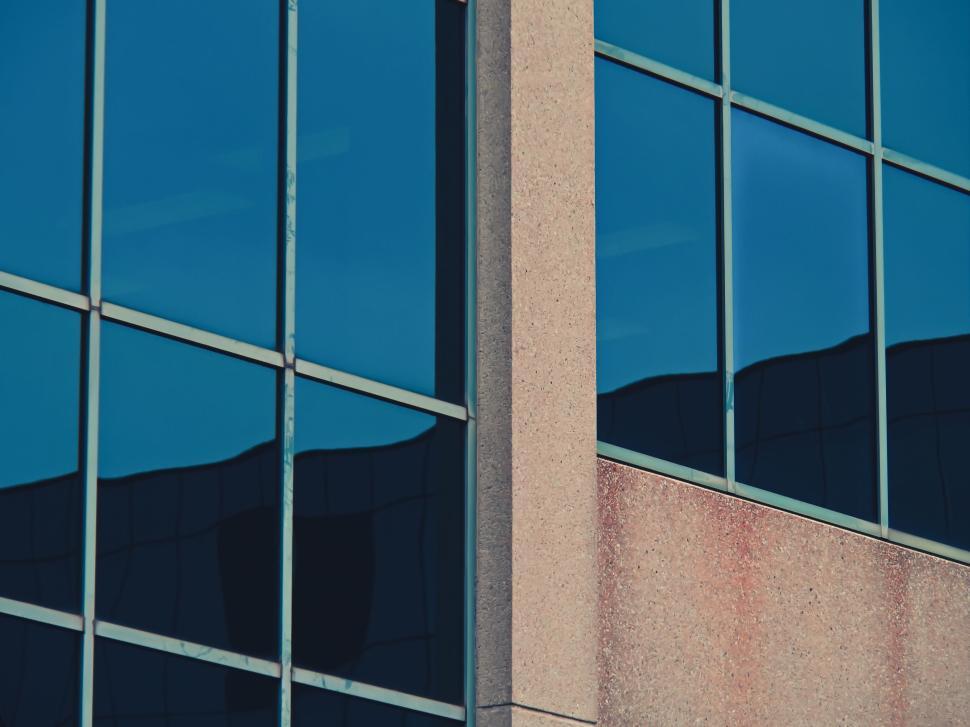 Free Image of Facade of a modern building with large reflective windows. 