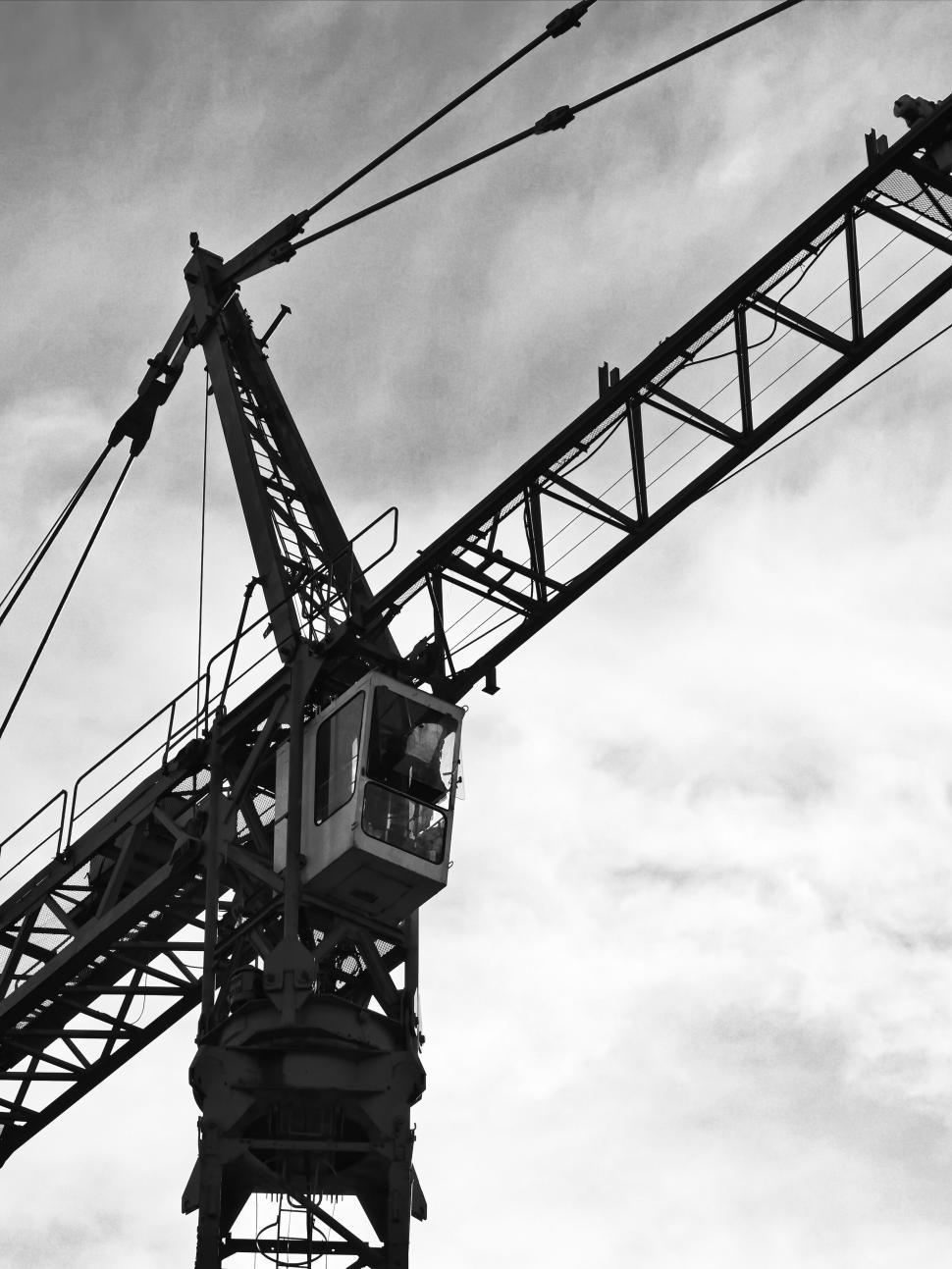 Free Image of Silhouette of a construction crane against a cloudy sky. 