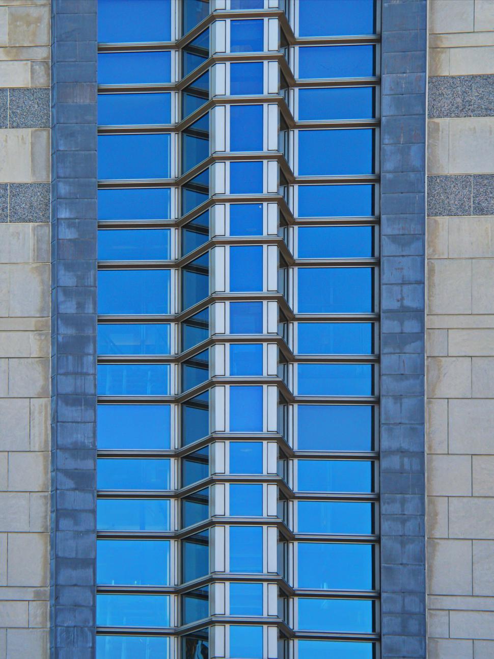 Free Image of Vertical glass tower with vivid blue reflective windows 