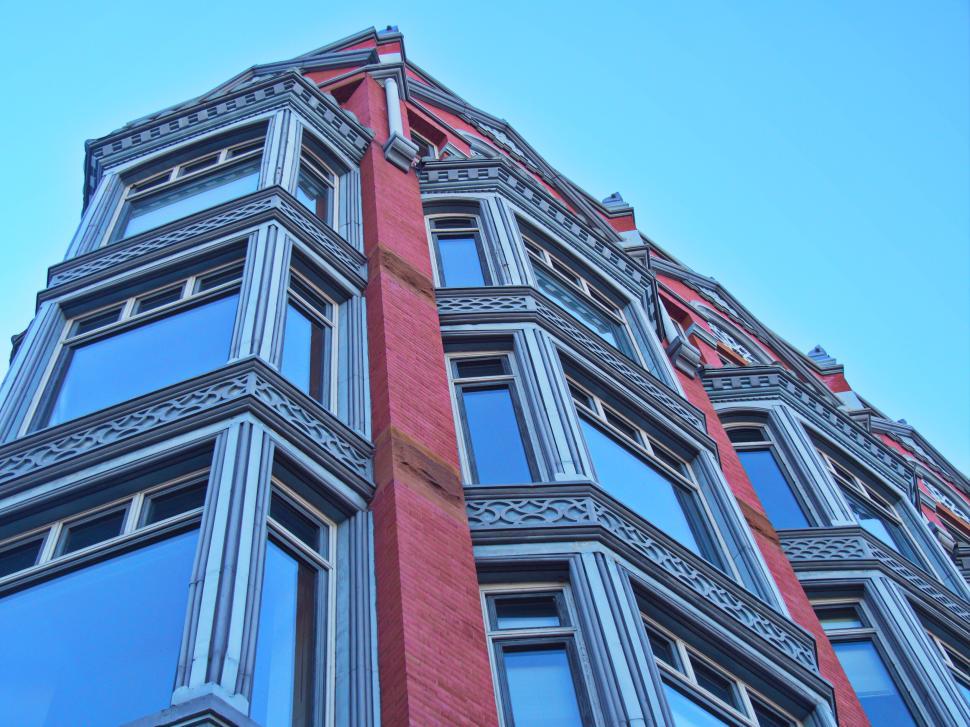 Free Image of Red brick building with large windows and ornate frames 
