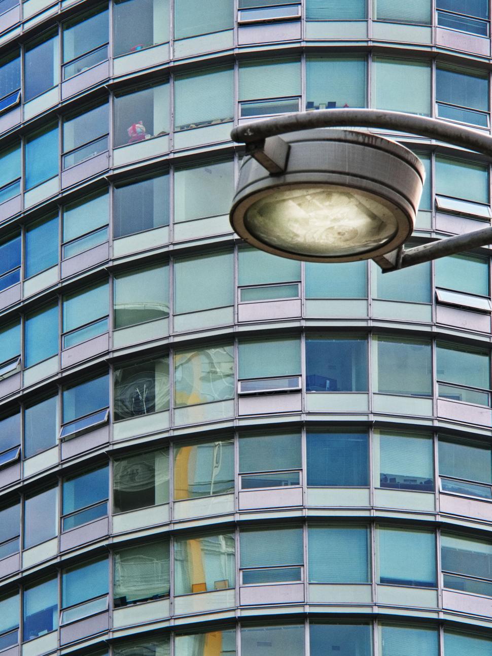 Free Image of High-rise building with glass windows and lamp post 