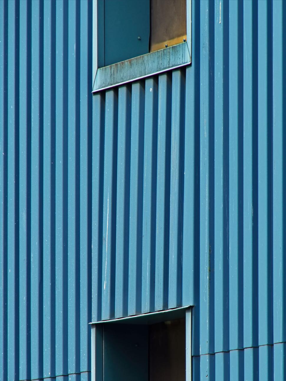 Free Image of Blue corrugated wall with windows in vertical lines. 