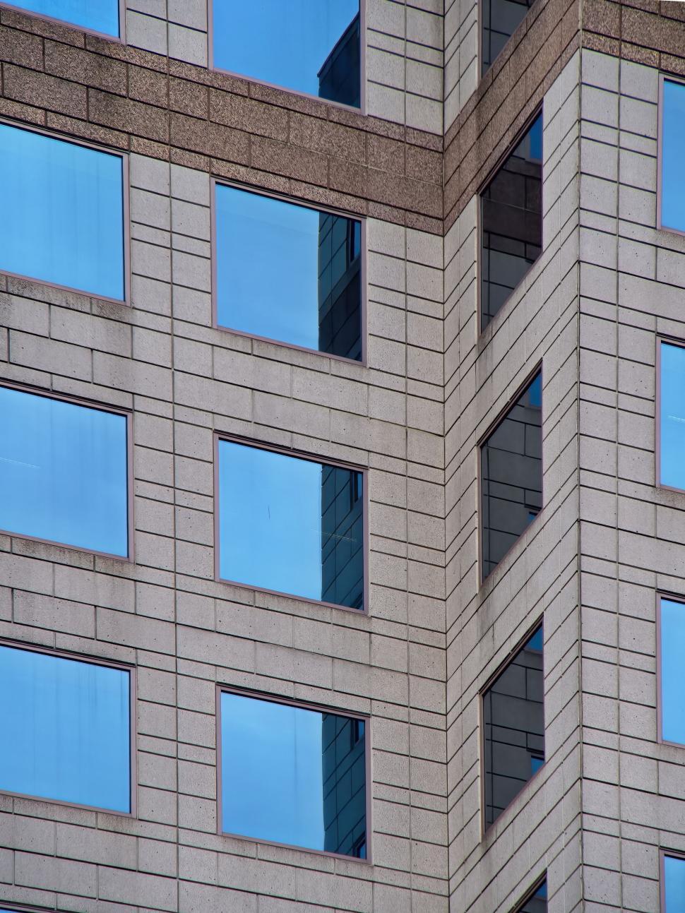 Free Image of Corner exterior of a tall building with many windows. 