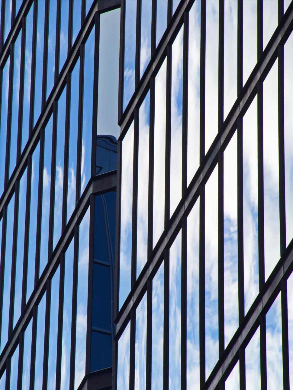 Free Image of Reflective glass building with blue sky reflections. 