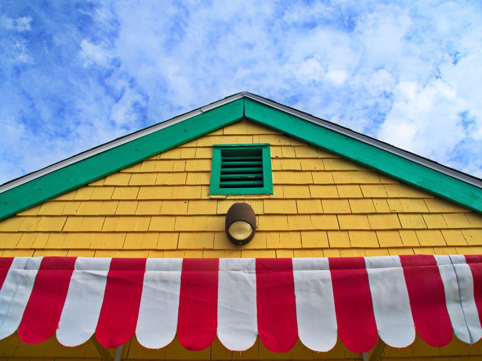 Free Image of Colorful wooden building facade with striped awning 