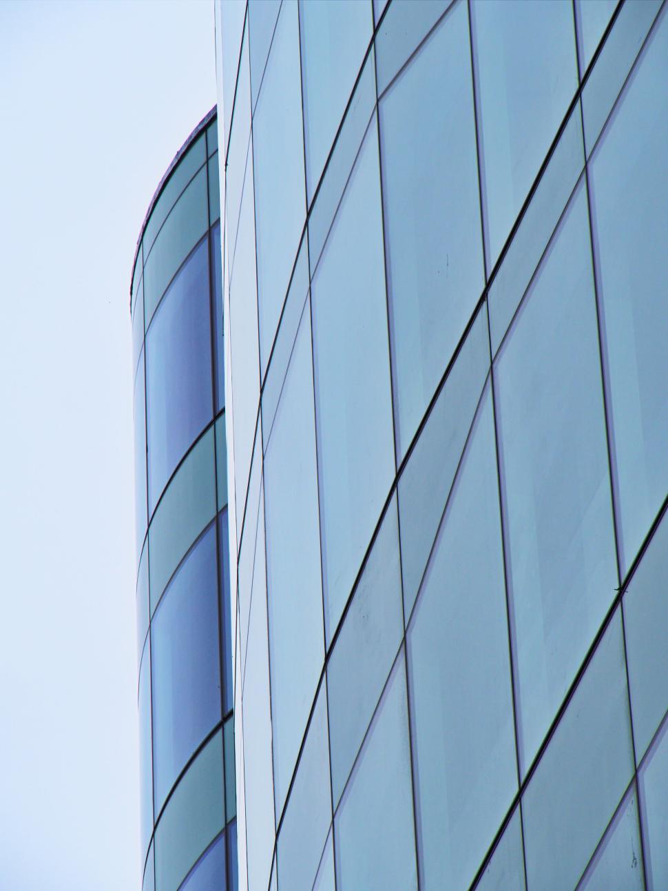 Free Image of Curved glass skyscraper with reflective windows surface 