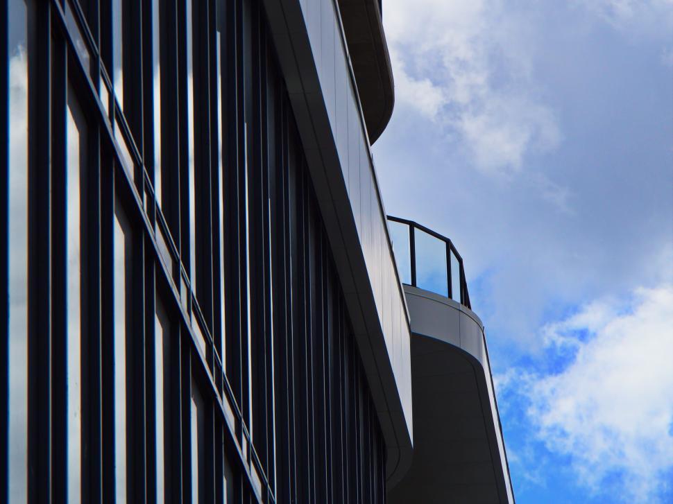 Free Image of Curved balcony and glass façade against cloudy sky 