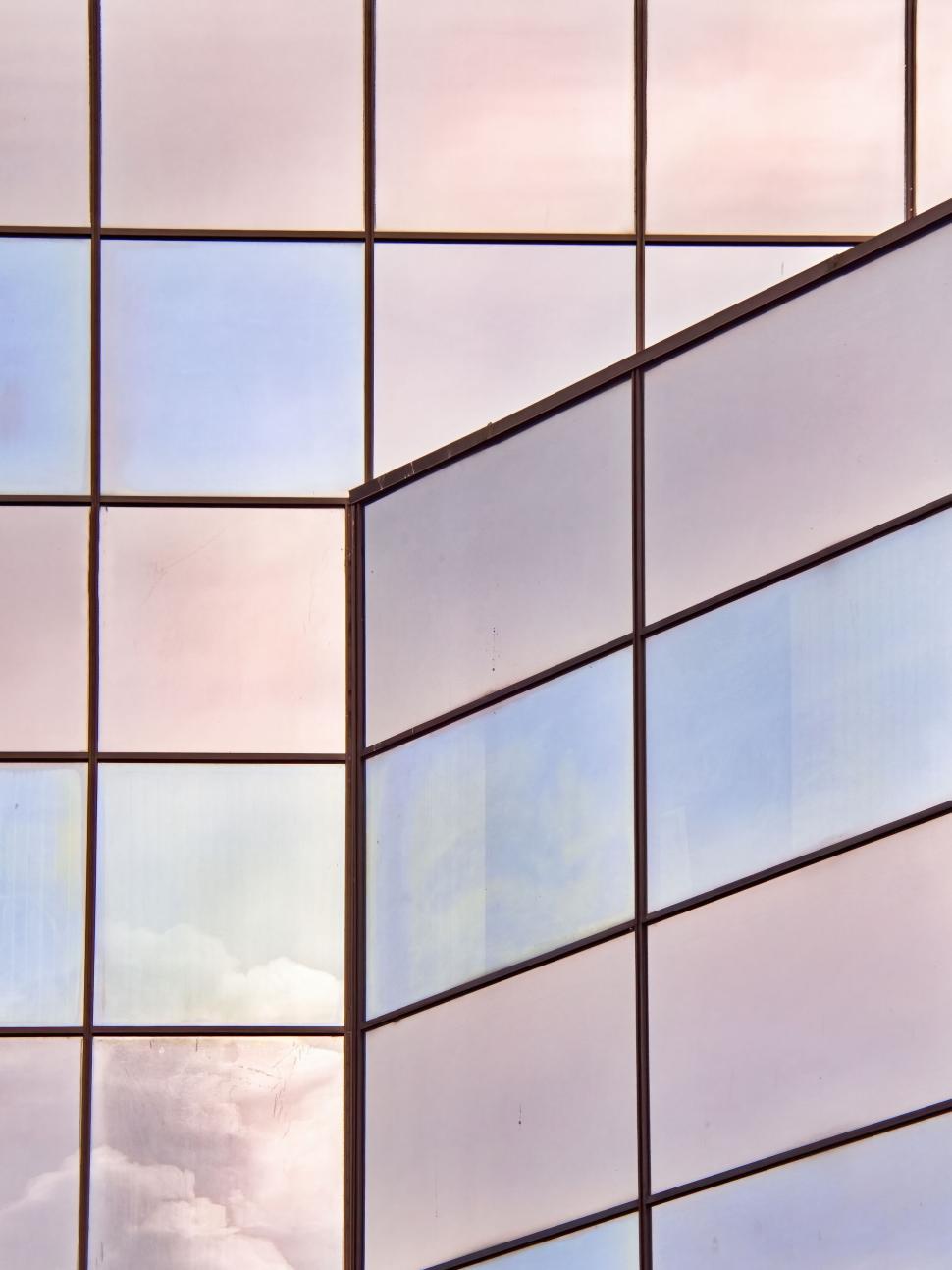 Free Image of Abstract glass structure reflecting sky and clouds 