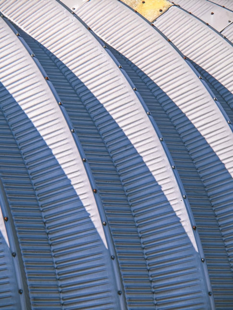Free Image of Textured metal roofing with diagonal shadows, close-up. 