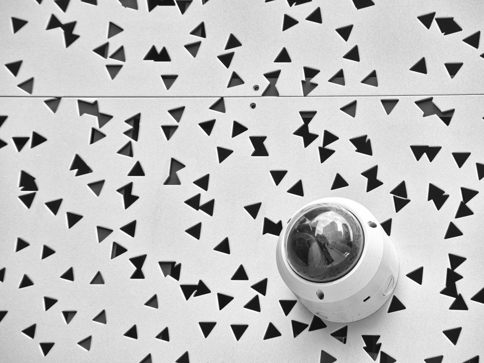 Free Image of Modern security camera on artistic perforated facade. 