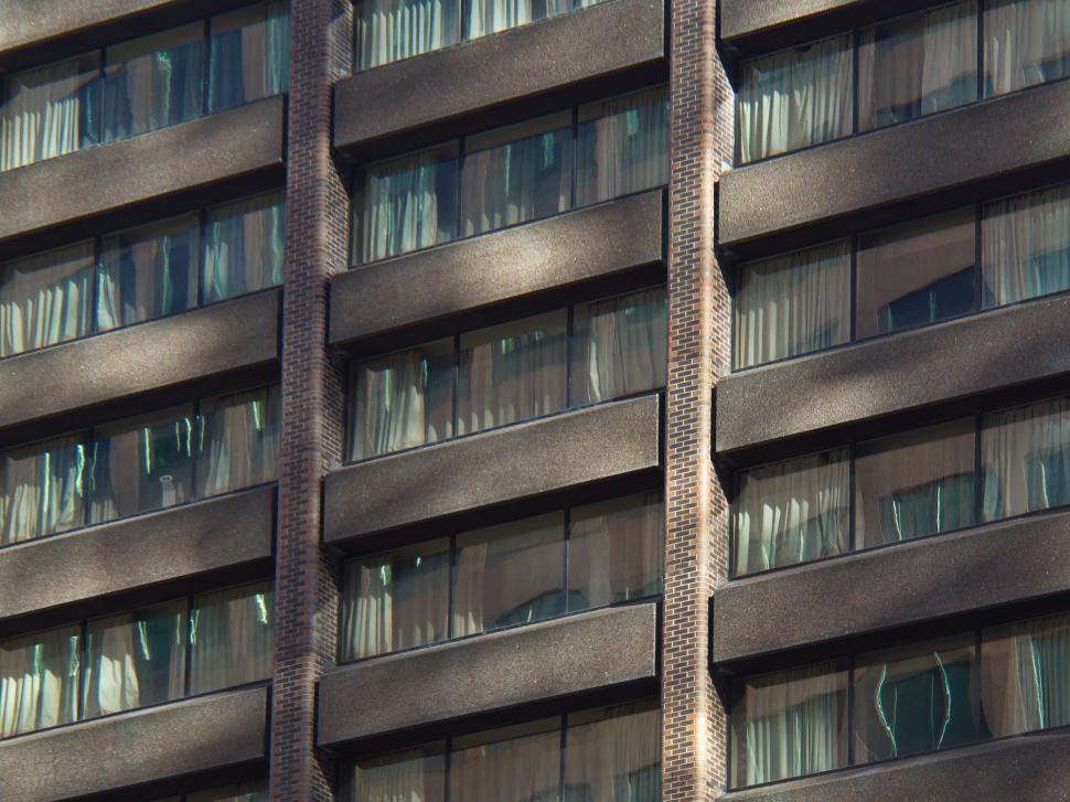 Free Image of High-rise building windows with curtains and reflections 