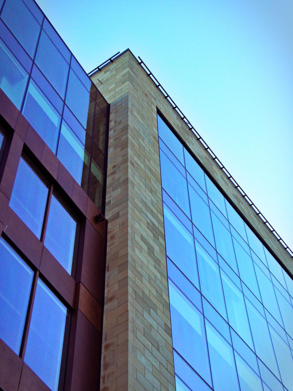 Free Image of Modern skyscraper with glass facade against blue sky 