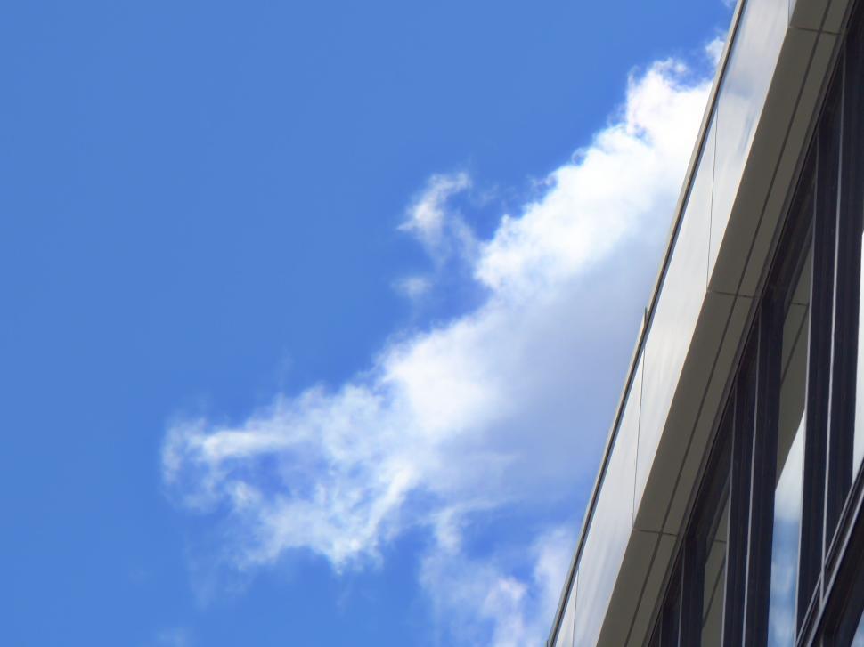 Free Image of Edge of a modern glass structure against a bright sky. 
