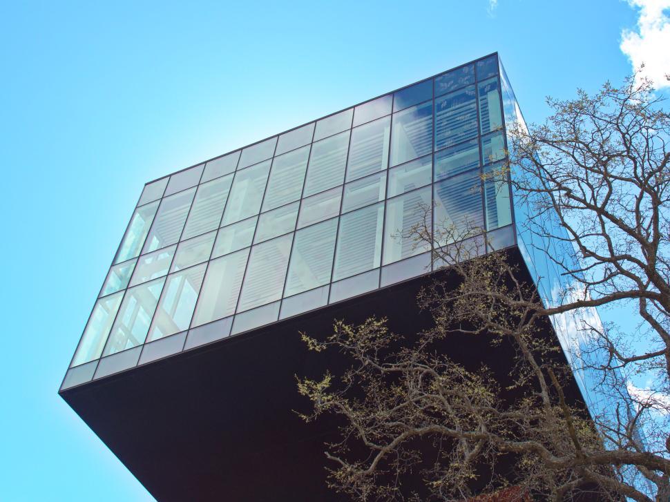 Free Image of Modern glass building with extended top structure design. 