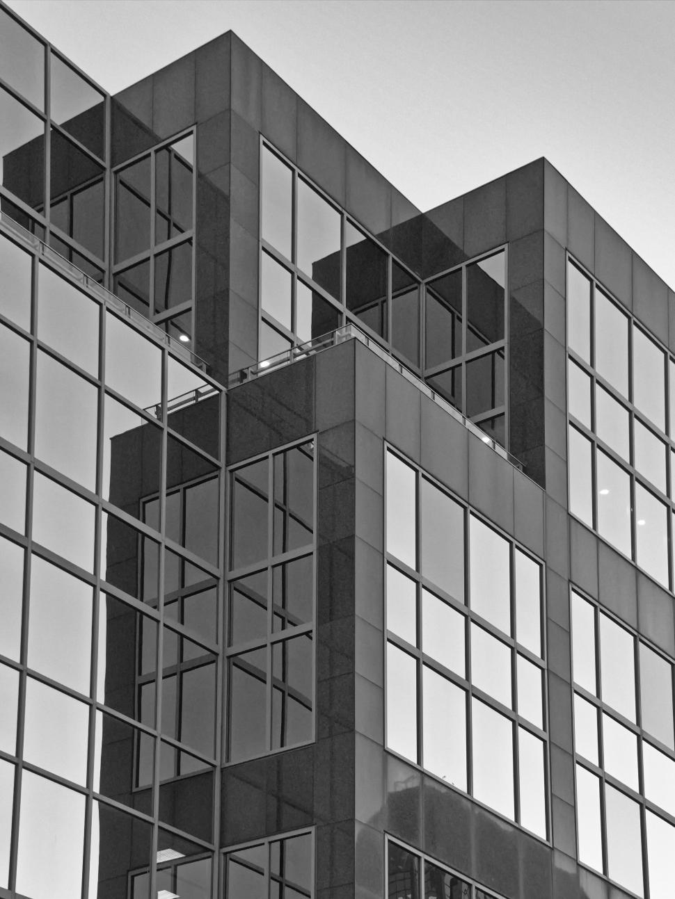 Free Image of High-rise office building with mirrored glass windows. 