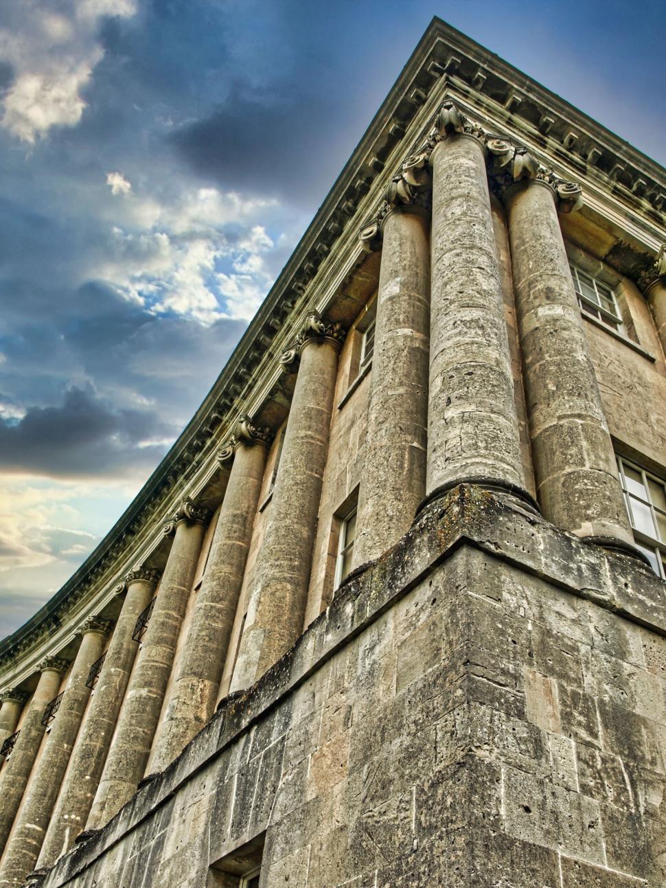 Free Image of Historic building with stone columns and dramatic sky above. 