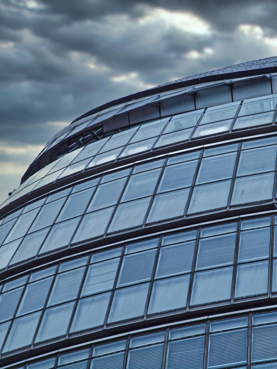 Free Image of Curved glass building under cloudy sky, contemporary design 