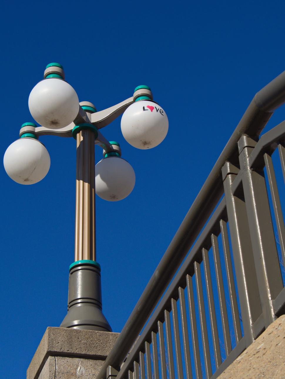 Free Image of Urban street lamp with  Love  text against clear blue sky 