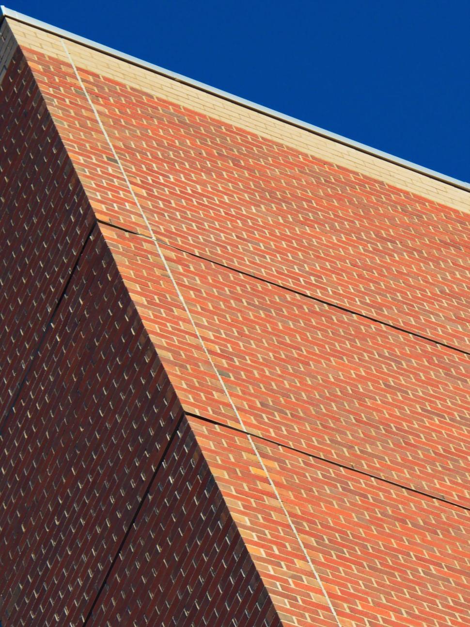 Free Image of Brick wall with sharp perspective against deep blue sky 