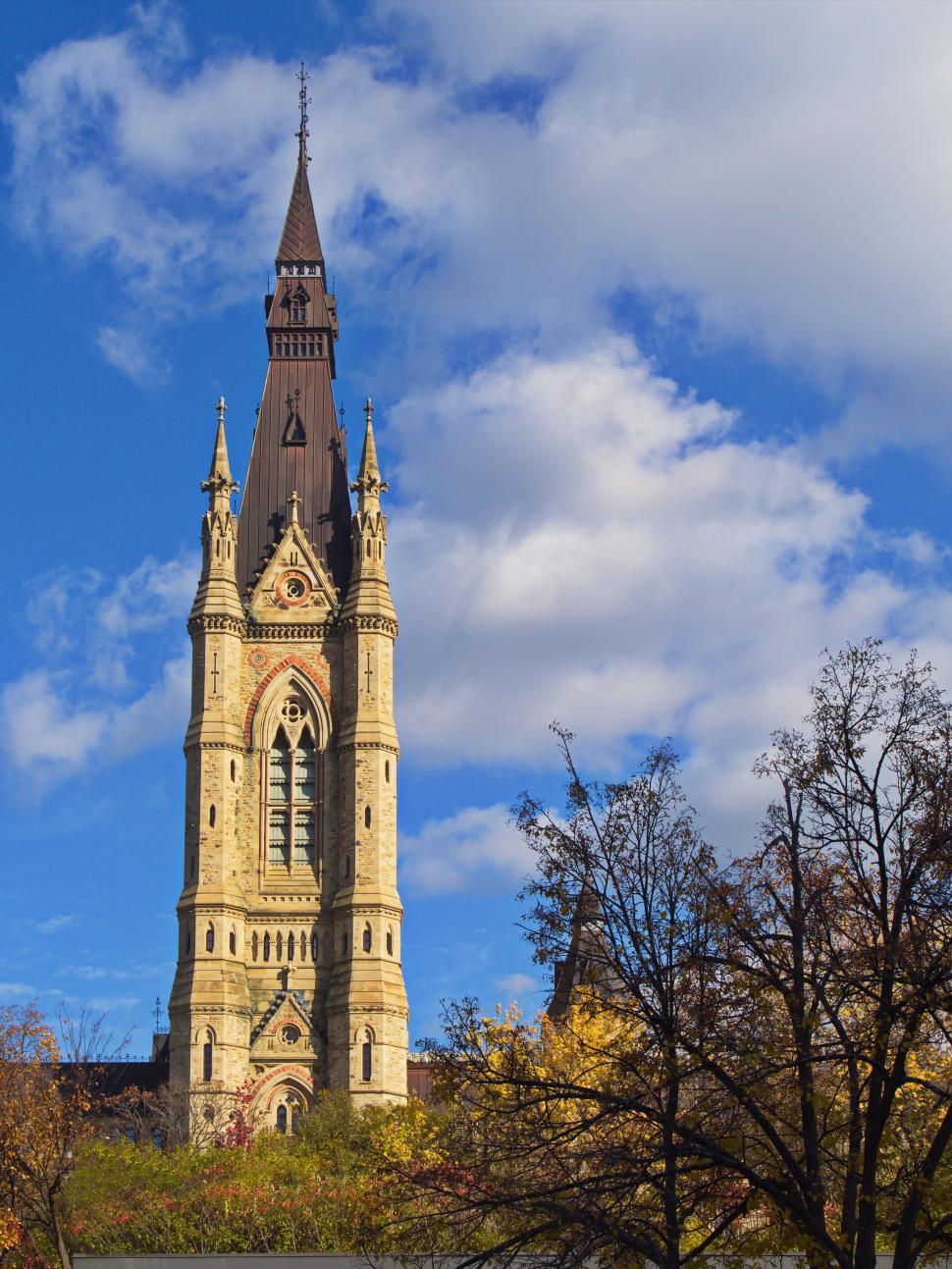 Free Image of Gothic style clock tower under a bright blue sky. 