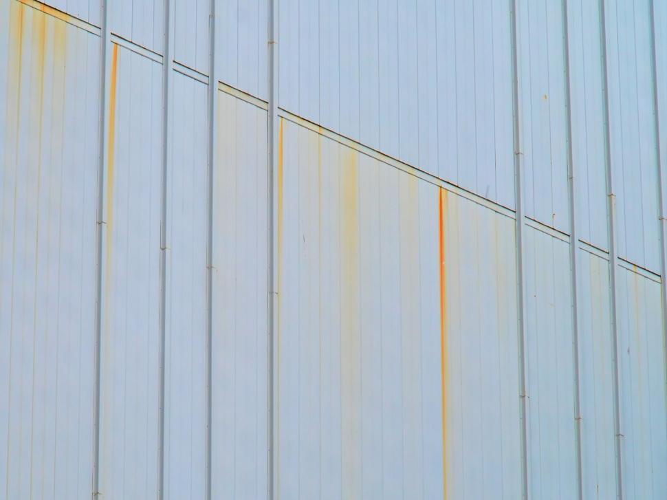 Free Image of Large industrial wall with vertical rusty streaks 