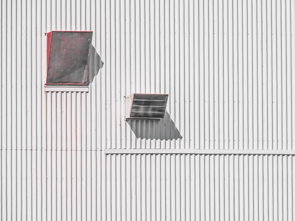 Free Image of Rustic white wall with two small windows and shadows 