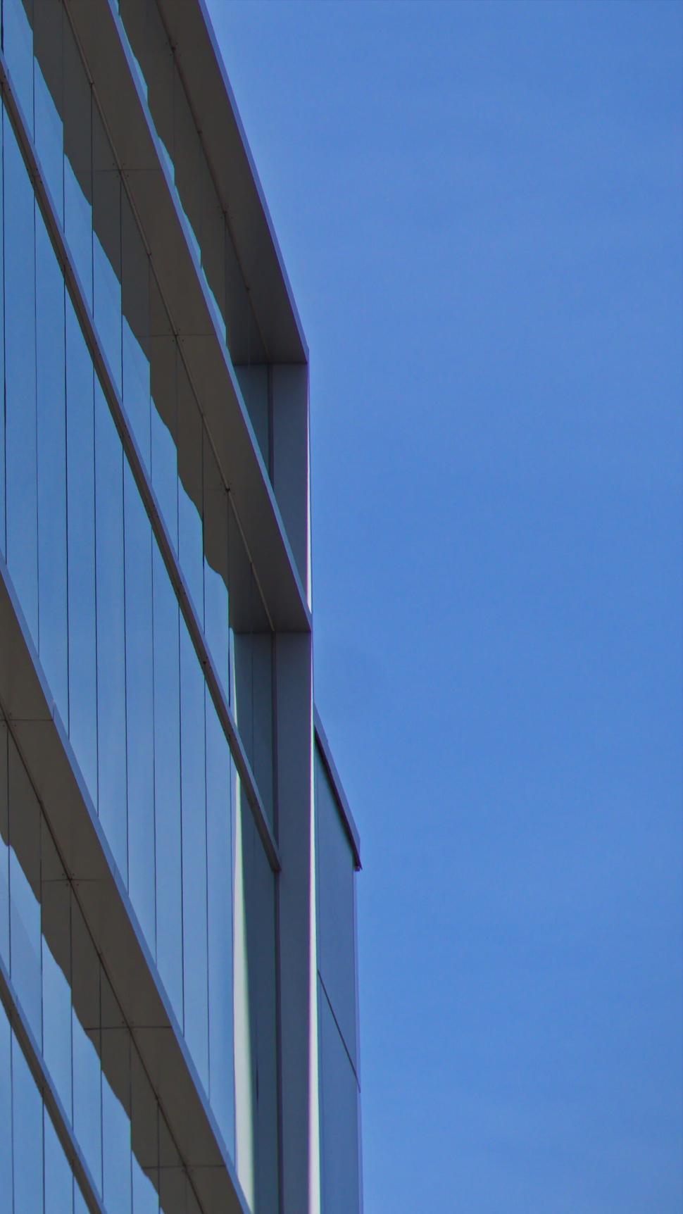 Free Image of Minimalist glass building with blue sky and clouds 