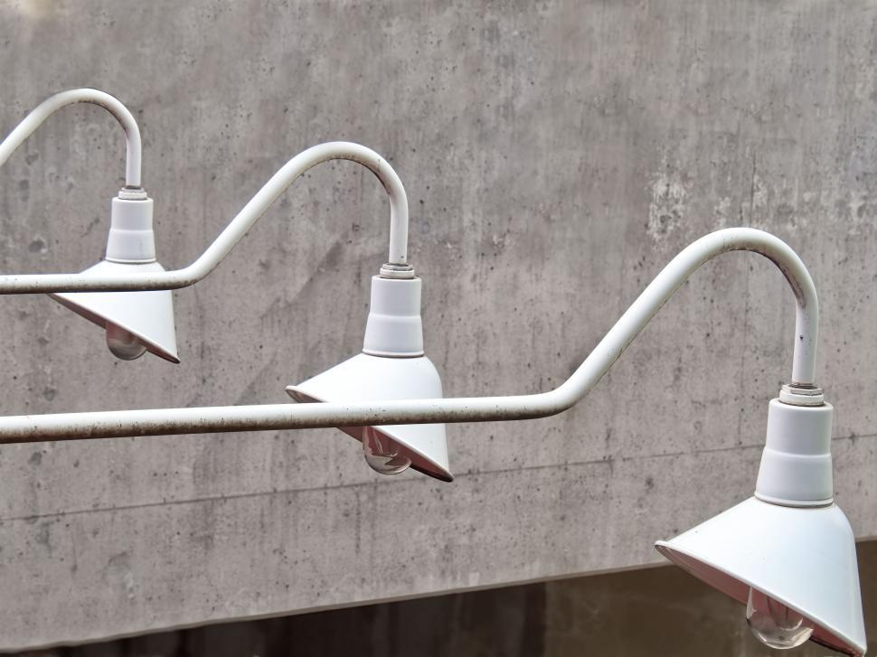 Free Image of Outdoor white light fixtures mounted on concrete wall 