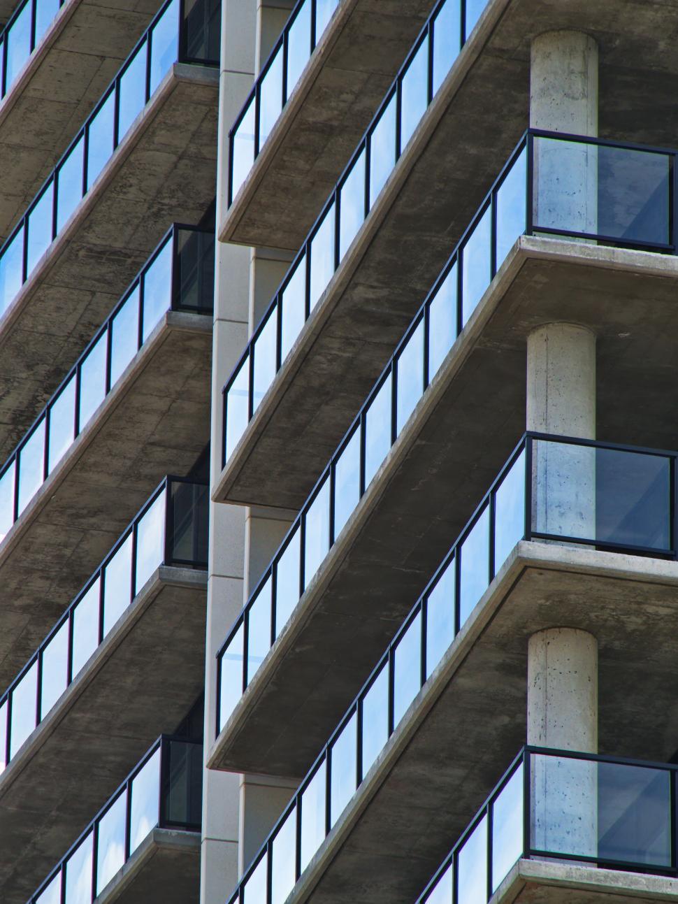 Free Image of Modern balconies with glass railings in a concrete building. 