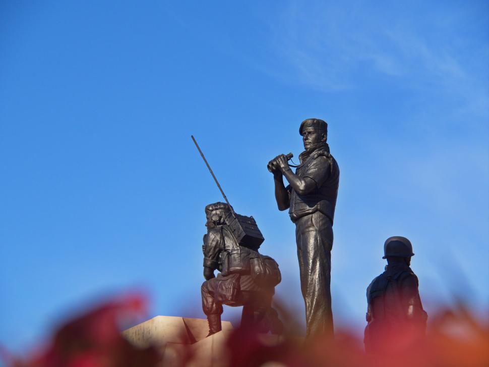 Free Image of Bronze statues of soldiers under a clear blue sky 
