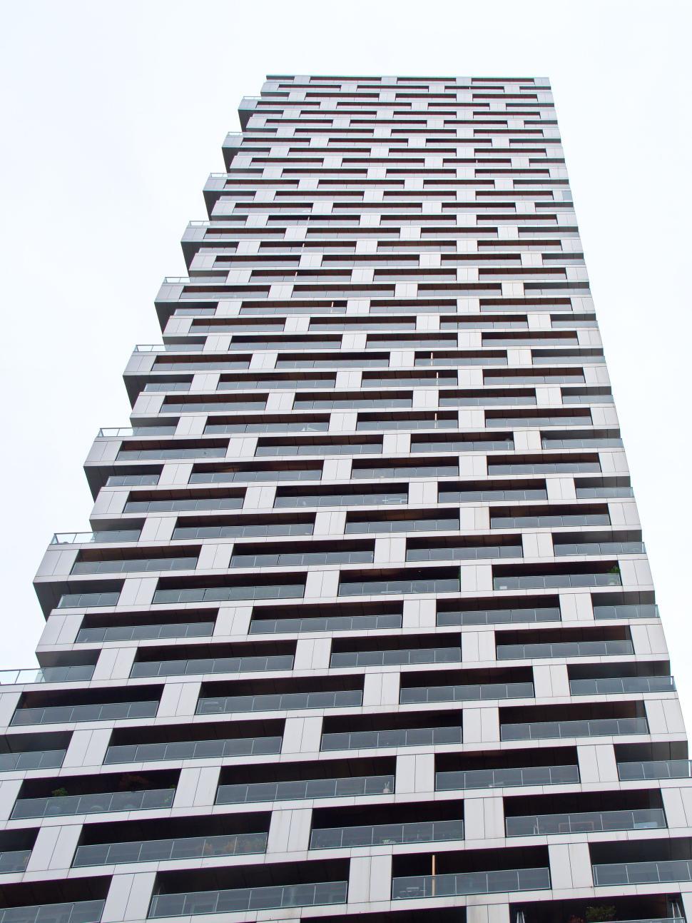 Free Image of Tiled pattern skyscraper disappearing into white sky 